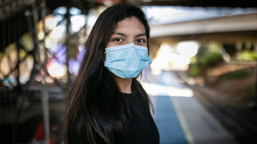 a young woman wearing a mask looking