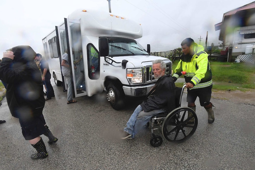 Paramedic wheels out resident towards a large van