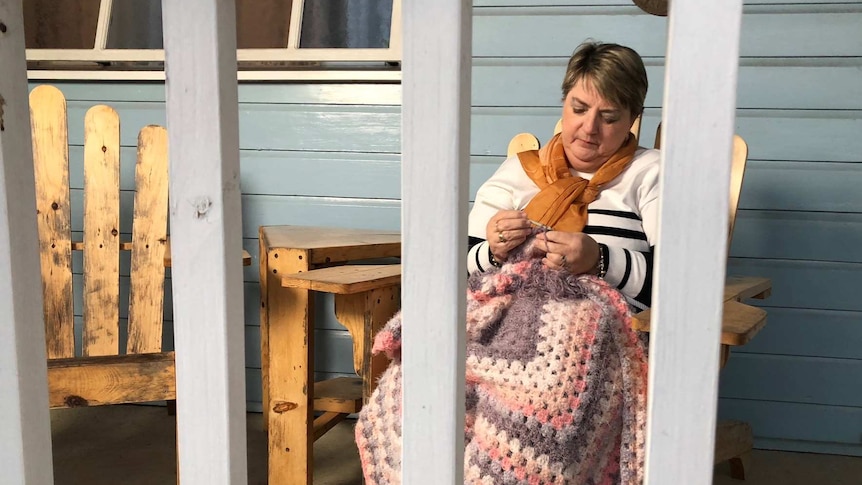 Debbie Thompson knits on her veranda