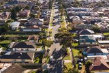 A drone shot of a residential street on the border of two suburbs.