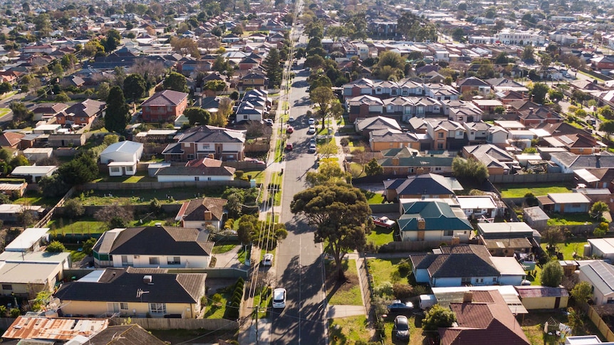 A drone shot of a residential street on the border of two suburbs.