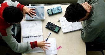 Two people complete homework at a desk.