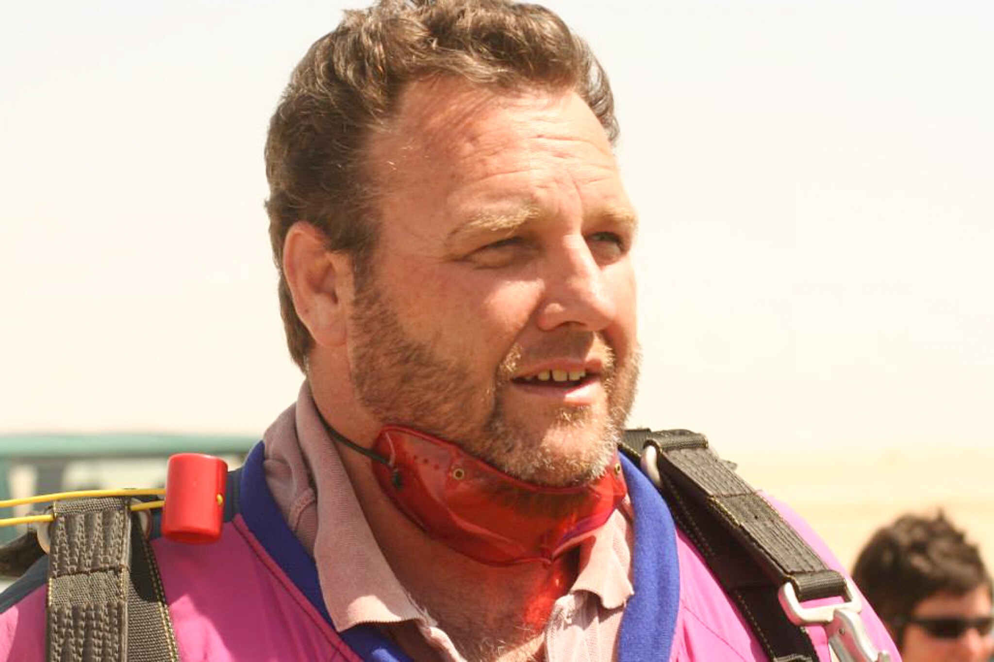 A close up of a man with blonde hair and a beard looking off in the distance
