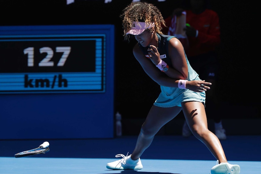Naomi Osaka looks at the racquet she has thrown on the court at the Australian Open.