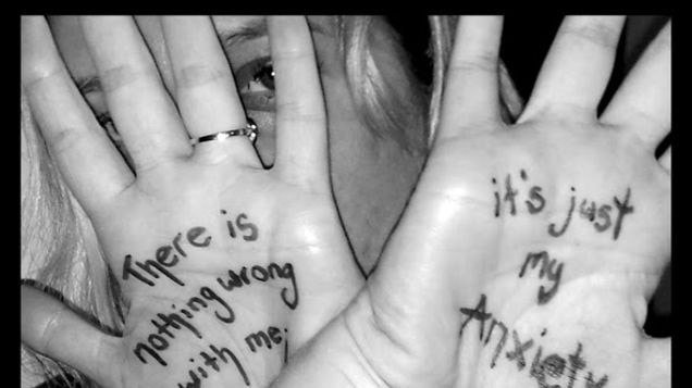 A woman holding her hands in front of her face with the words "There is nothing wrong with me… it's just my anxiety" written.