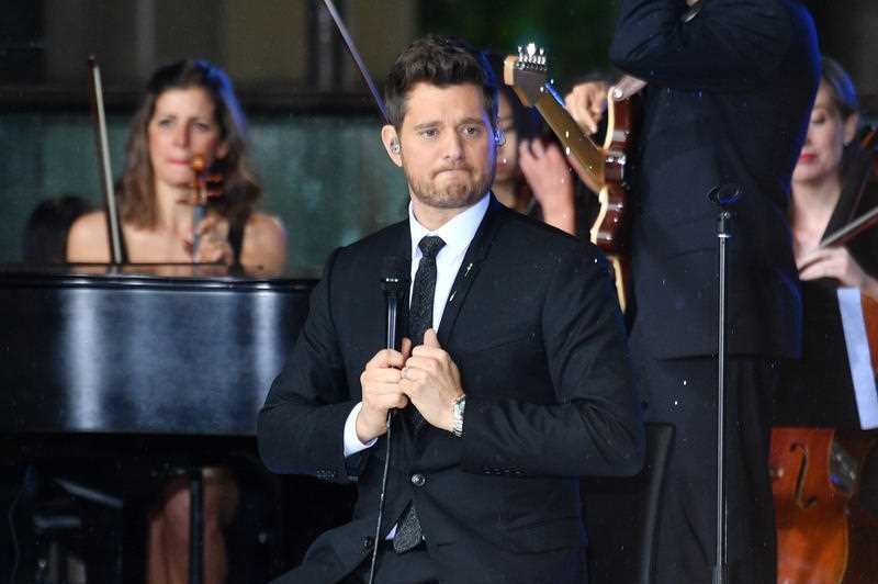 A man sitting on a stage singing.