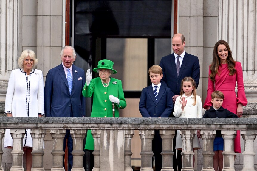 The royal family stand on the balcony and wave to the public.