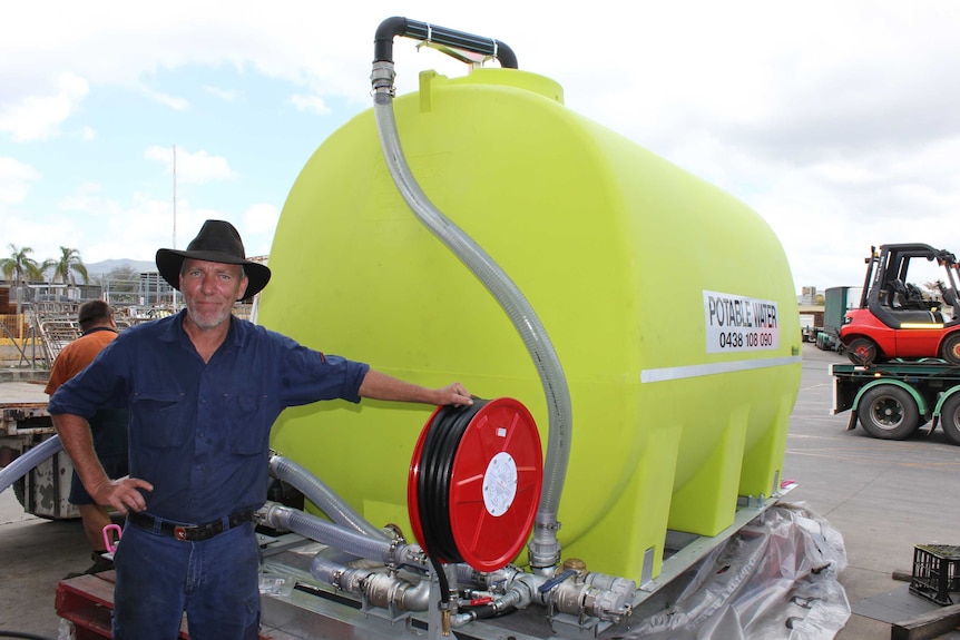 man in front of water tank