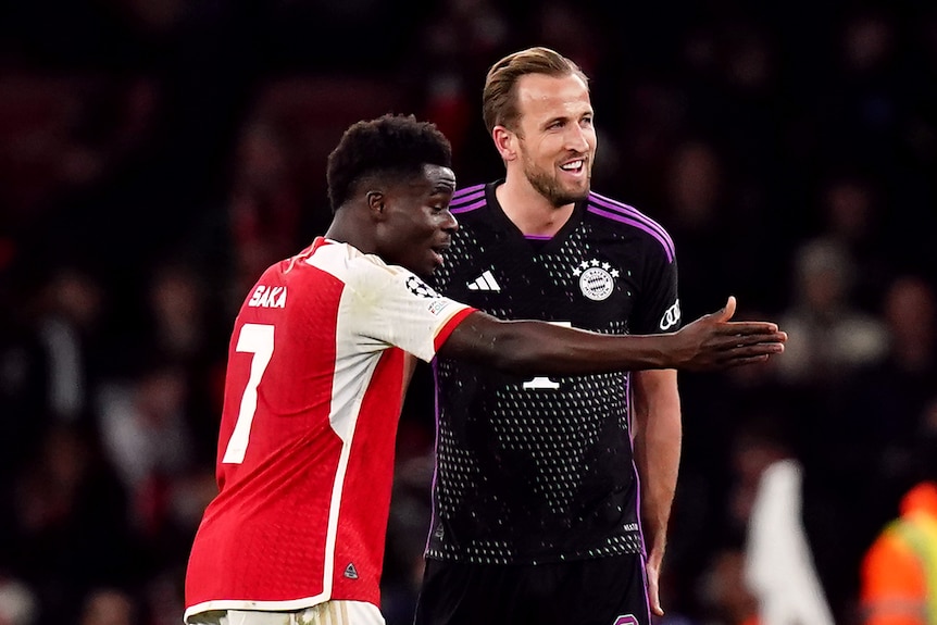 Arsenal's Bukayo Saka gesticulates as he speaks to Bayern Munich's Harry Kane after a Champions League game.