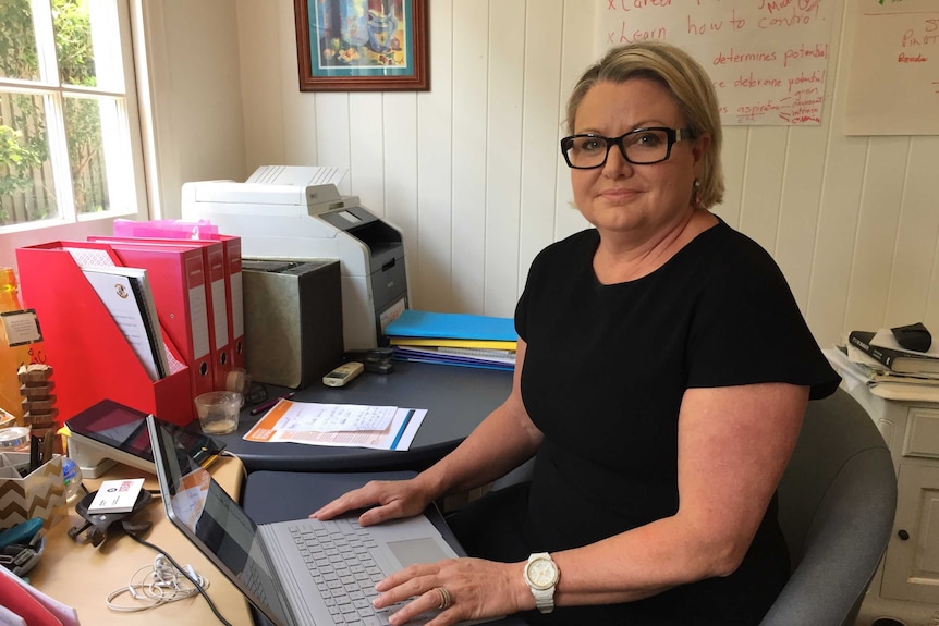 Mum Libby Marshall sits at a desk.