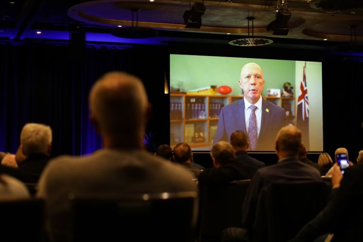 Peter Dutton s'exprimant sur grand écran lors d'une conférence 