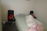 A room inside an illegal brothel ACT Policing shut down, with bed, chair, money and bin among the objects inside.
