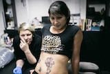 Scars of domestic violence attack concealed by tattoo art.