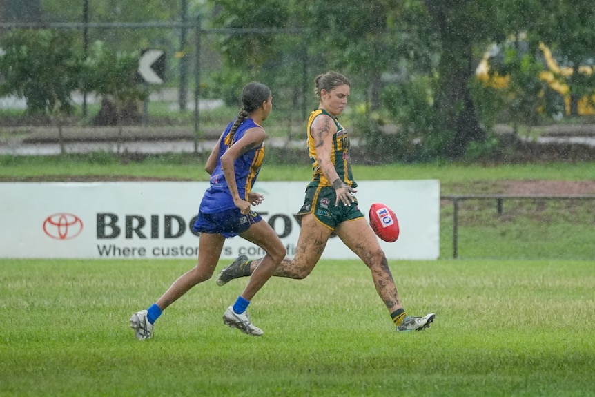 A PINT player kicks the ball forward as the rain comes down.