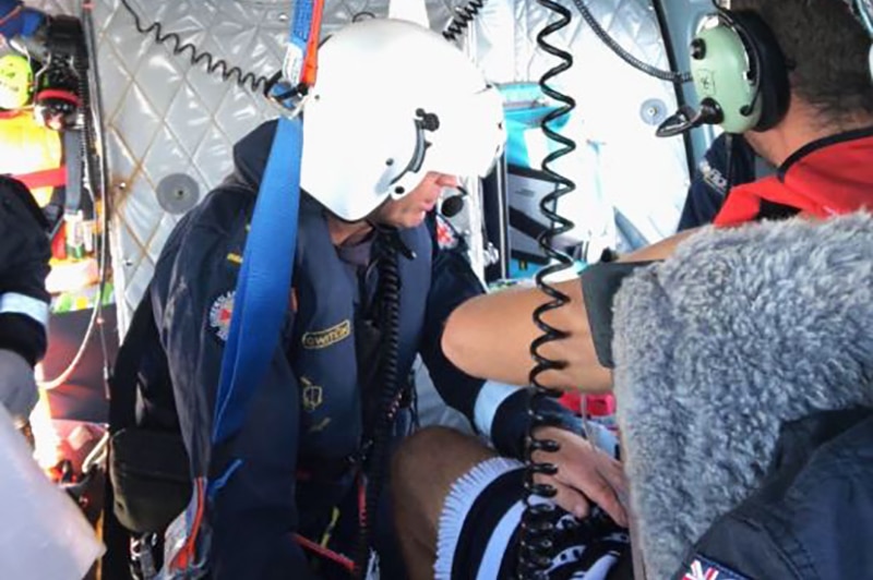 A helicopter paramedic treating a patient injured on the leg