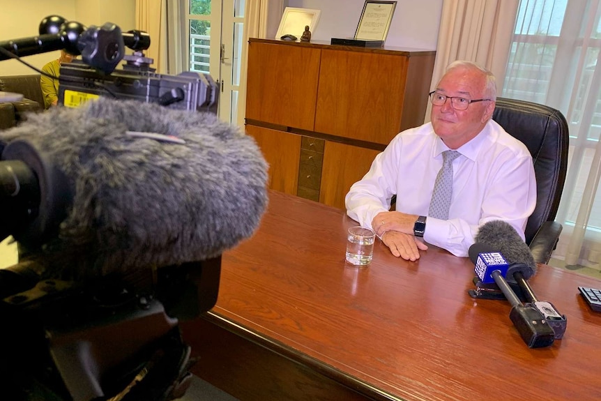 Gary Higgins sits at a table during a press conference.