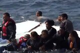 Migrants on top of a sinking boat off Greece's coast