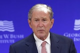 George W Bush stands behind a podium while making a speech in New York.