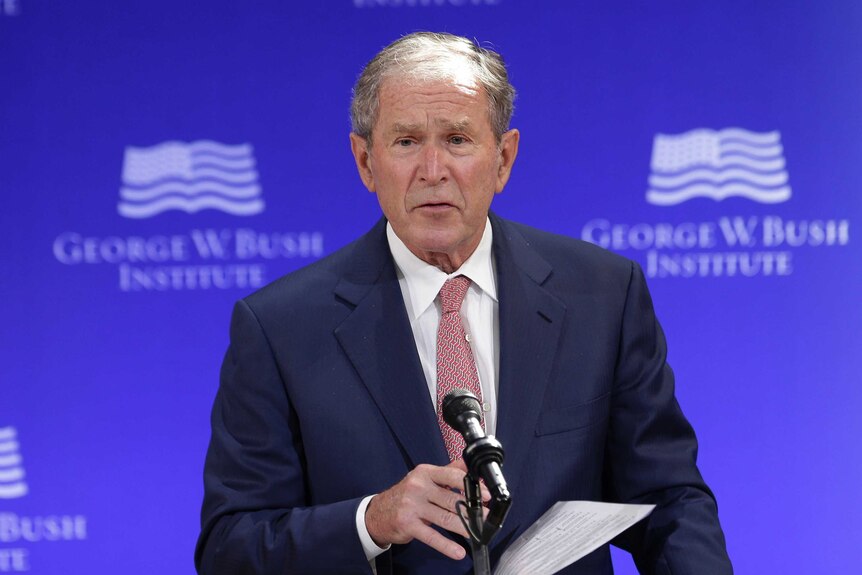 George W Bush stands behind a podium while making a speech in New York.