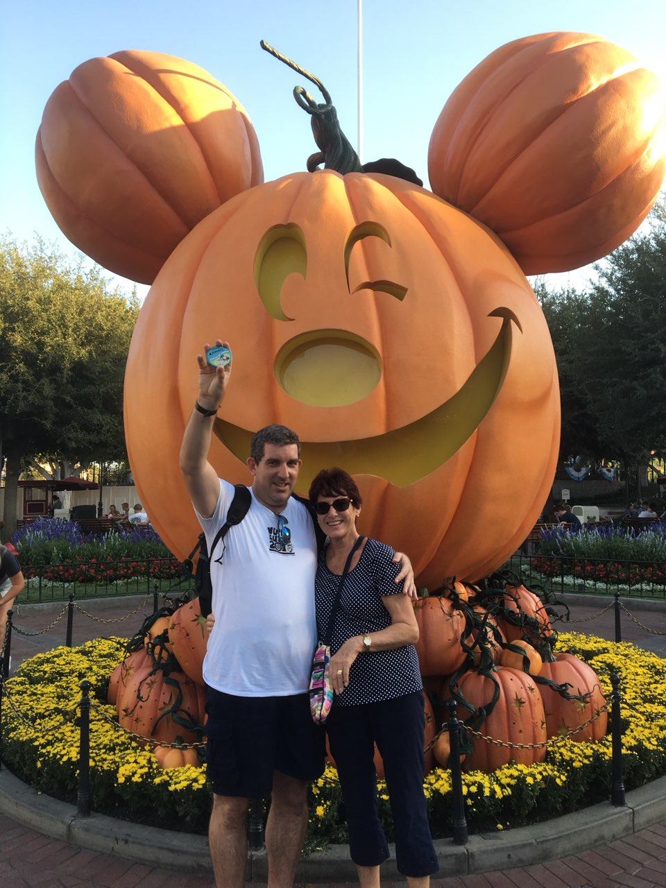 Man and woman in front of Disney carved pumpkin