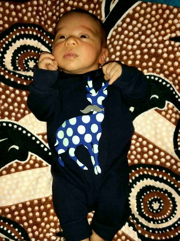 A baby on a brown colourful background