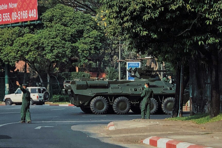 Army soldiers clear the traffic as an armoured personnel vehicle moves on a road in Yangon, Myanmar,