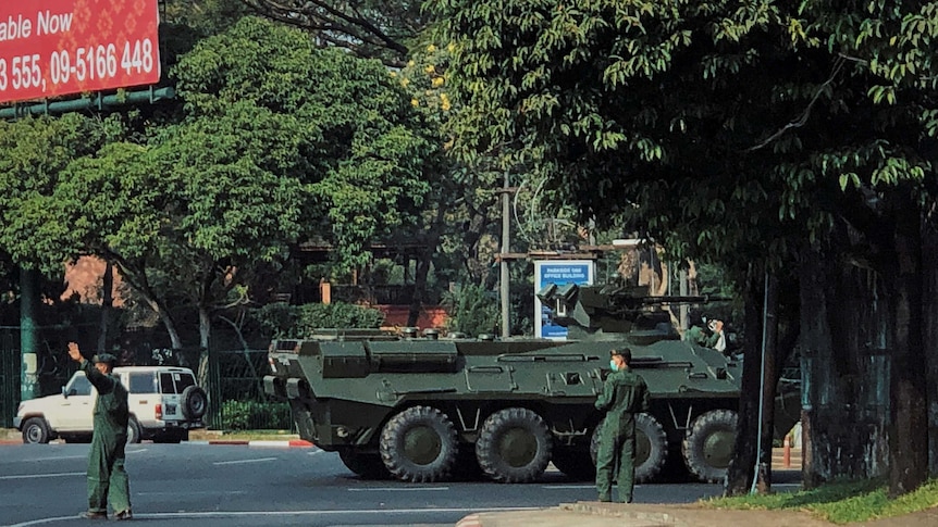 Army soldiers clear the traffic as an armoured personnel vehicle moves on a road in Yangon, Myanmar.