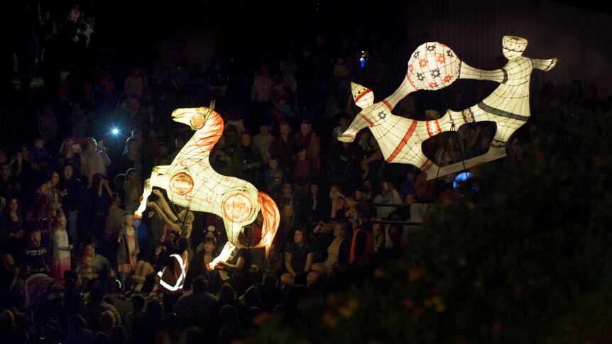 Illuminated figures move through the crowd during the Moon Lantern Parade at the OzAsia Festival.