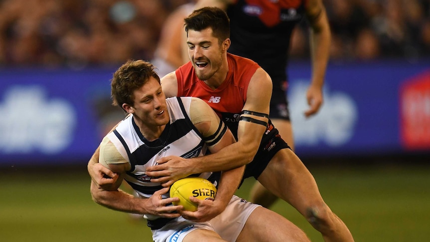 Jed Bews (L) of the Cats is tackled by Bayley Fritsch of the Demons.