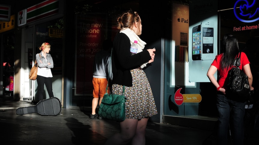 Young woman walks with mobile phone