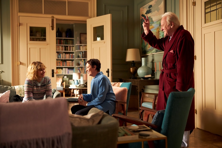 Imogen Poots, Olivia Colman and Anthony Hopkins all talking in a lounge in the film The Father