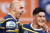 Two Parramatta Eels players celebrate a try being scored against the Brisbane Broncos.