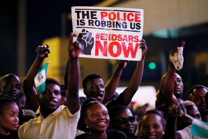 A demonstrator holds a sign during a protest over alleged police brutality in Lagos, Nigeria.