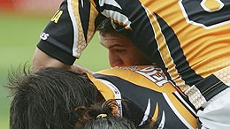 Warriors lock Sione Faumuina is tackled by the Tigers defence