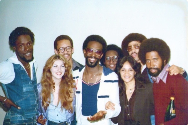 Lori Balmer poses in a group photo with band members of The Commodores