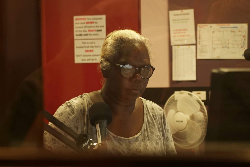 A photo of Sylvia Nulpinditj looking at a computer screen as she does show prep.