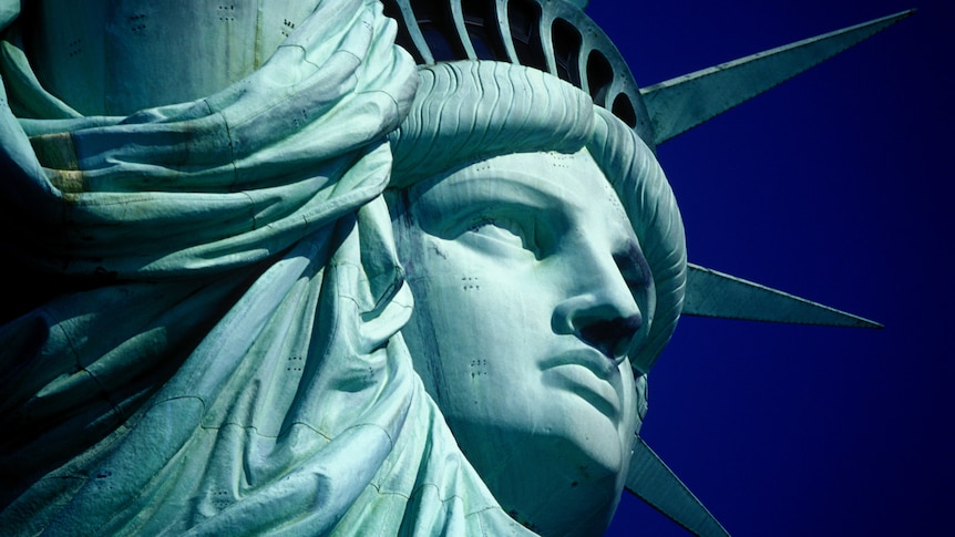 Close up of head of Statue of Liberty with blue sky in the background