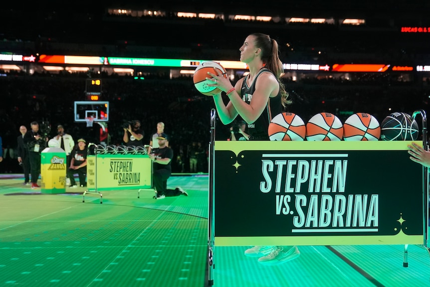 Sabrina Ionescu lines up a shot in her three-point shootout with Stephen Curry at NBA All-Star Weekend.