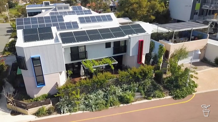 Aerial view of apartments with produce garden and solar panels on the roof