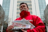 A Sun newspaper seller stands outside News International headquarters in London