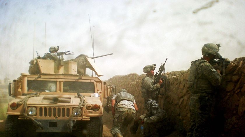 Soldiers run as a firefight breaks out