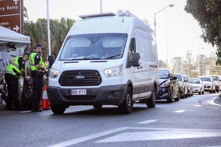 Motorists queue at a police checkpoint on the Queensland-NSW border on the Gold Coast.