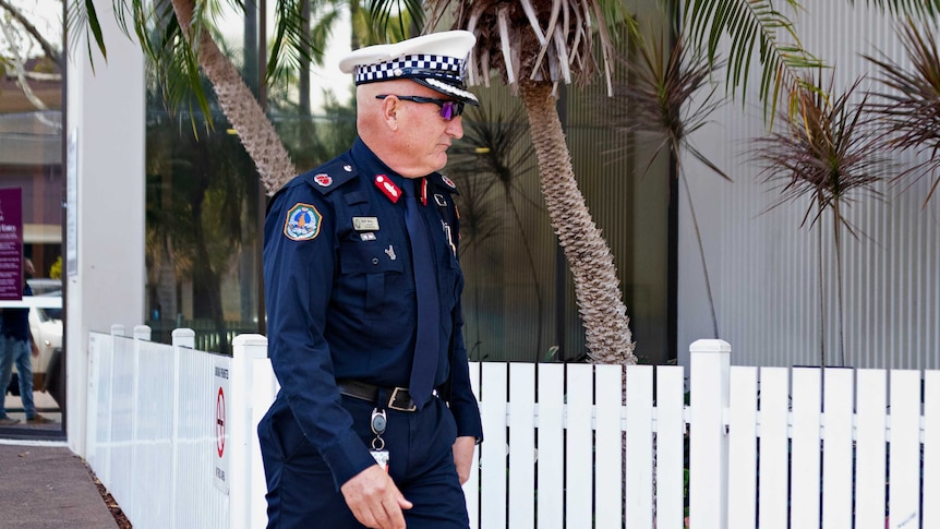 Assistant Commissioner Nick Anticich is wearing a navy NT Police uniform, a cap, and sunglasses as he leaves court.