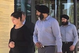 Jatinder Panesar walks outside a court building, accompanied by two men and a woman.