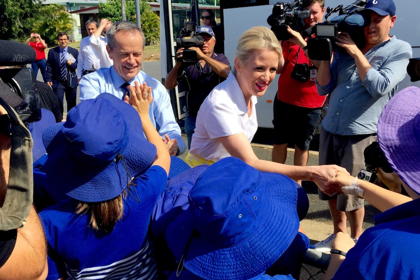 Bill Shorten and Chloe shake hands with school children.