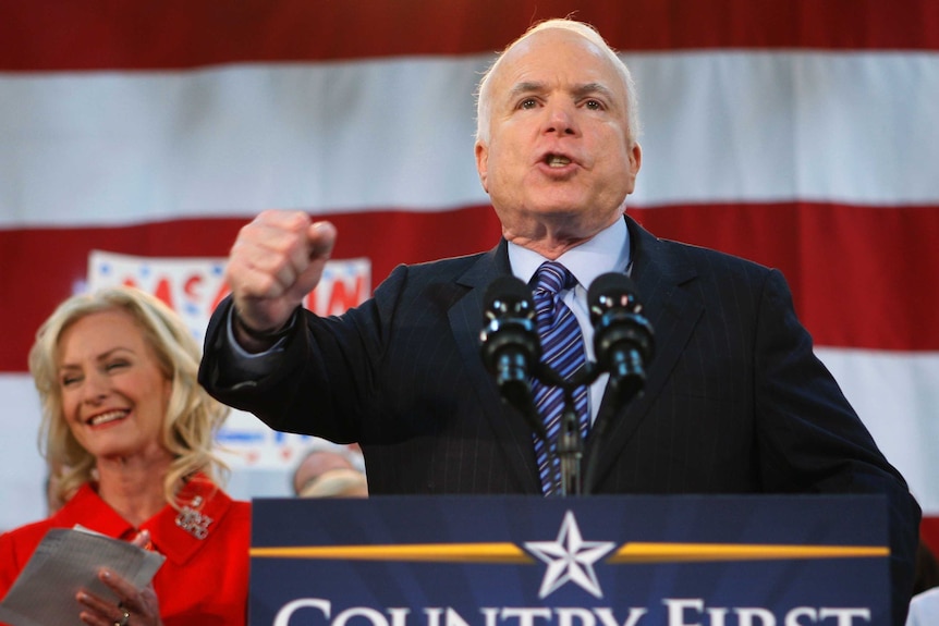 Republican John McCain gives a speech standing with his wife Cindy