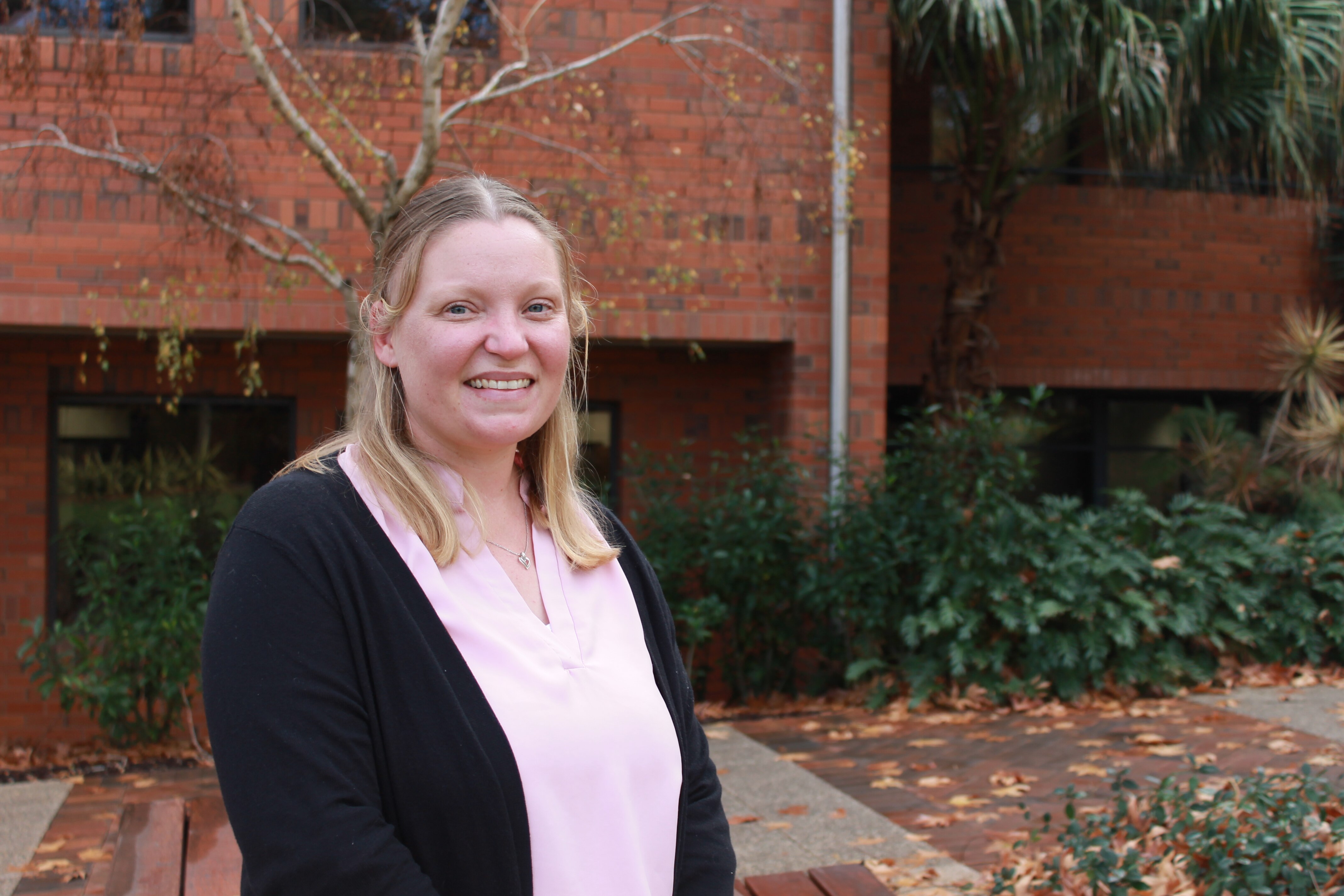 A woman with blonde hair smiles at the camera.