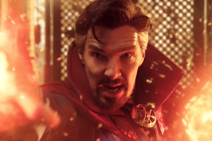 Doctor Strange, a goateed superhero in a cape, yells as red special effects suggest a spell