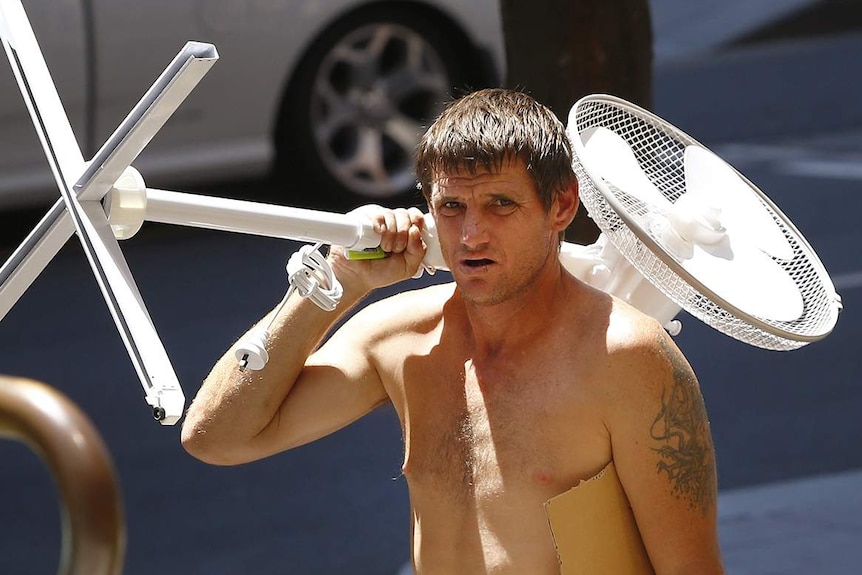 A man carries a fan