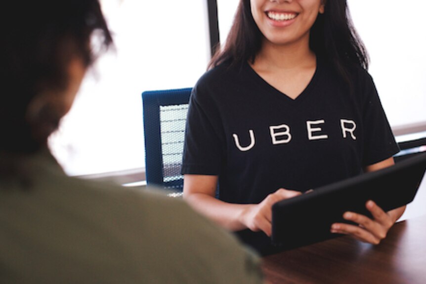 A smiling employee at one of Uber's greenlight hubs.